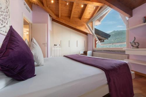 a bedroom with a large bed with a large window at Luxury Lakefront Maisonette in Lezzeno