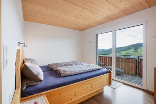 a bedroom with a bed and a balcony at Ferienwohnung Blösling 2 in Bernau im Schwarzwald