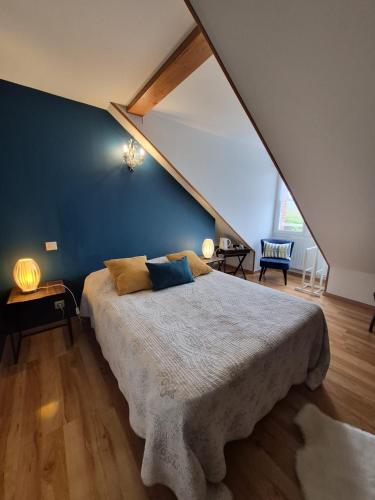 a bedroom with a large bed with a blue wall at Pré en Bulles in Trépail
