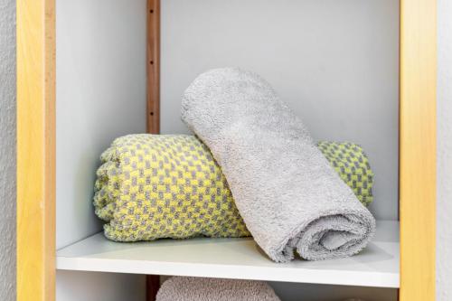 a towel on a shelf with two pillows at room4you in Hemmingen