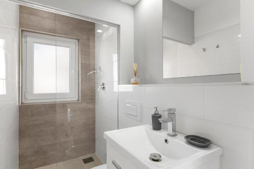 a white bathroom with a sink and a shower at Antogil-mata1 in La Mata