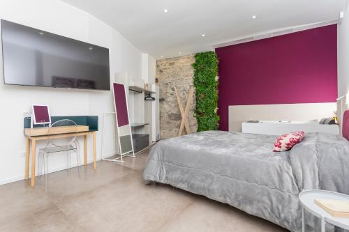 a bedroom with a bed and a purple wall at Taormina Center Suite with Jacuzzi in Taormina