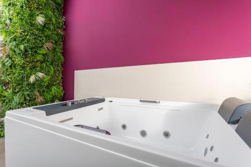 a white bath tub in front of a colorful wall at Taormina Center Suite with Jacuzzi in Taormina