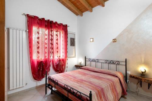 a bedroom with a bed with red drapes at Agriturismo Green House in Santo Stefano al Mare