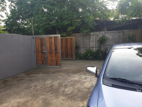a car parked next to a fence with wooden doors at Beachhouse for 15 pax with pavilion in Nasugbu