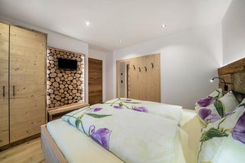 a bedroom with a bed and a wooden wall at Waldes Duft Apartment - Patleidhof in Naturno