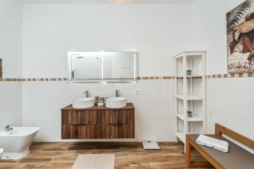 a bathroom with two sinks and a mirror at Sunlit Modern Stay in Arona