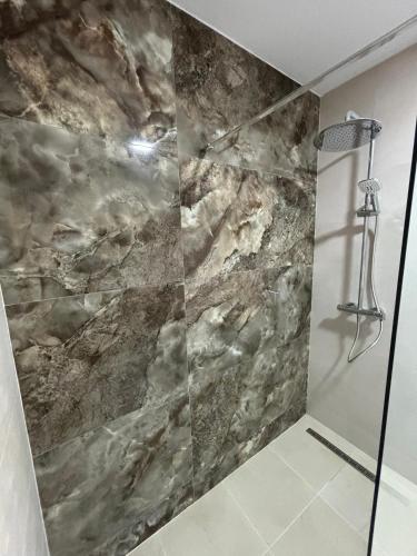 a shower in a bathroom with a stone wall at Casa Montelado in Mijas