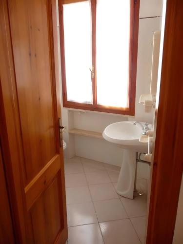 a bathroom with a sink and a toilet and a window at Apartments Porto Ottiolu Mare in Porto Ottiolu