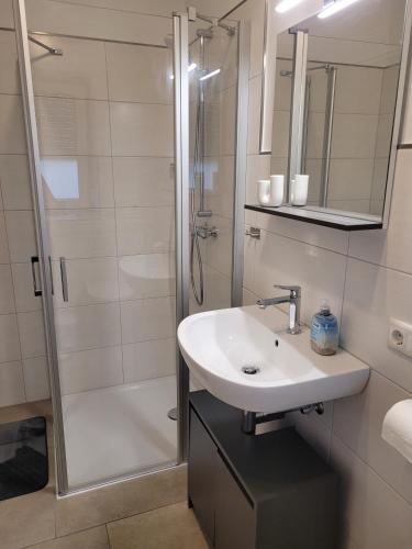 a white bathroom with a sink and a shower at Rike in Oesterdeichstrich