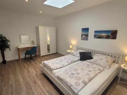 a bedroom with two beds and a table and a desk at Rike in Oesterdeichstrich