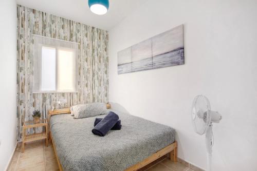 a small bedroom with a bed and a fan at Casa Relax in Costa Calma