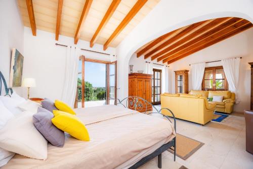 a bedroom with a large bed and a yellow couch at Siesta del Sol in Manacor