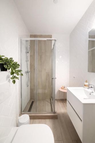 a bathroom with a shower and a toilet and a sink at Ametist in Mamaia