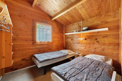 a room with two beds in a log cabin at Chalet confort 18 in Saint-Gervais