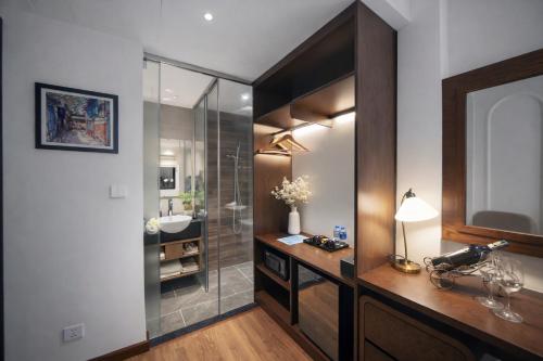 a bathroom with a glass shower and a sink at L'amant de Hanoi Hotel in Hanoi