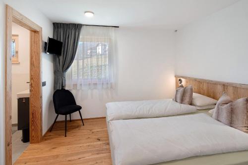 een slaapkamer met een bed, een bureau en een raam bij Cesa Pattis in Mazzin