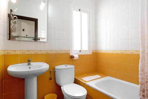 a bathroom with a toilet and a sink and a tub at Casa Paqui 2 in Roche
