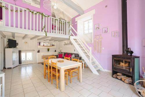 una stanza con un tavolo e sedie e una scala di Gite l'Escapade a Saint-Nazaire-sur-Charente