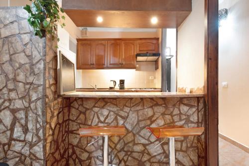 a kitchen with a sink and a counter with two stools at Residencial Primavera in Arona