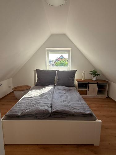 a white bed in a room with a window at Ferienquartier alte Bäckerei in Feldberg