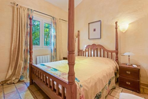 a bedroom with a wooden bed and a window at Villa - La Mignonette avec terrasse in Cavalaire-sur-Mer