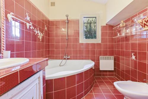 a red tiled bathroom with a tub and a sink at Villa - La Mignonette avec terrasse in Cavalaire-sur-Mer