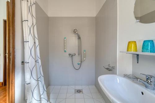 a white bathroom with a shower and a sink at Gîte Jasmin in Plavilla