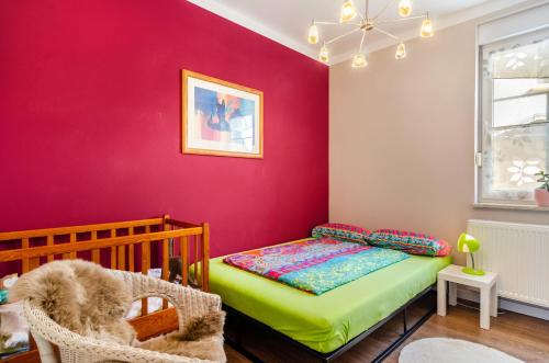 a bedroom with a bed and a red wall at Fewo Theo im Ferienhaus Alte Schule in Ferna