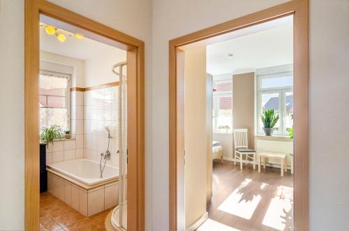 a bathroom with a tub and a shower and a sink at Fewo Theo im Ferienhaus Alte Schule in Ferna