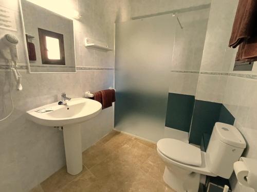 a bathroom with a white toilet and a sink at Hostal Horizonte in San Antonio