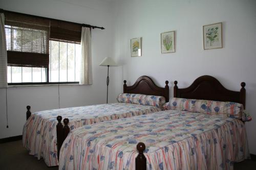 a bedroom with two beds and a window at Quinta da Eira in Lagoa
