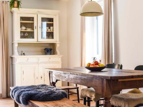 a dining room with a wooden table with a bowl of fruit at Ferienwohnung Im Weiler, 70 Qm in Winterlingen