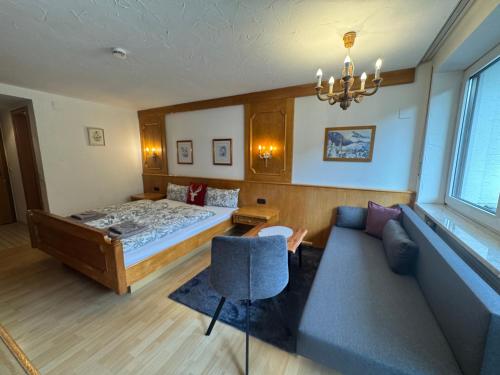a bedroom with a bed and a couch at Gästehaus Babel in Pfronten