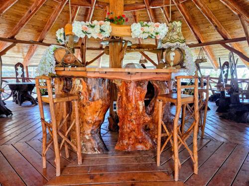 a large wooden table with a tree stump centerpiece at Pensiunea Emma in Sâmbăta de Sus