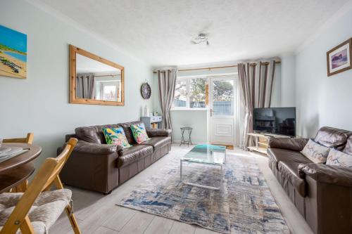 a living room with two brown couches and a table at Dolphin Cottage - Short walk to Poole Quay with Private Garden in Poole