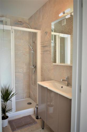 a bathroom with a shower and a sink and a tub at T2 Le Bougainvillier Cassis in Cassis
