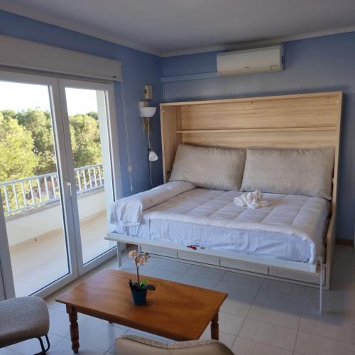 a bedroom with a bed and a table and a window at Apartamento Portosun Estrella in Portocolom