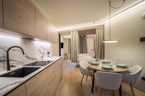 a kitchen with a table and chairs and a sink at Avia Living Teresa in Brunico