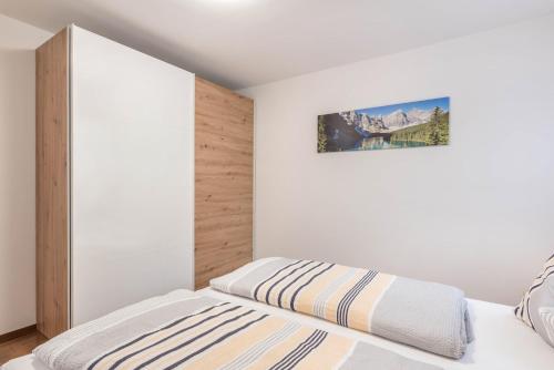 a bedroom with a bed and a painting on the wall at Trojer Apartment 1 in Sarntal