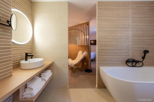 a bathroom with a white tub and a sink at Maison Bourgeoise de caractère in Tarare