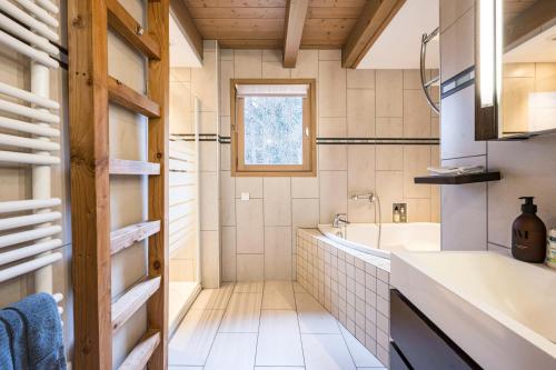 a bathroom with a tub and a sink at Chalet Coeur de Savoie in Cléry