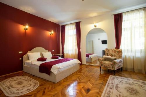a bedroom with a bed and a chair at Margarethengasse Comfort Rooms Old Town in Sibiu