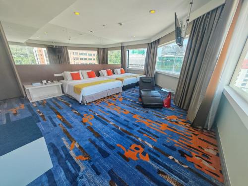 a bedroom with a bed and a blue carpet at Hotel Capital Kota Kinabalu in Kota Kinabalu