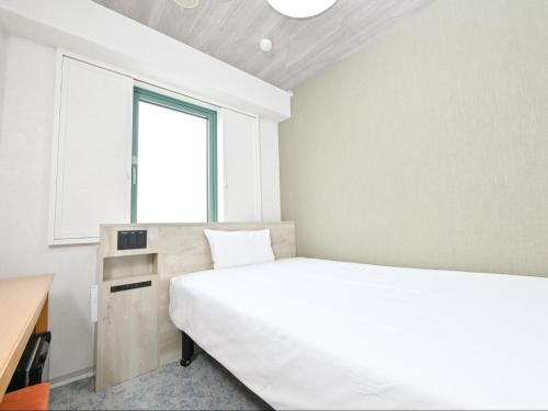 a bedroom with a white bed and a window at Sanco Inn Kuwana Ekimae in Kuwana