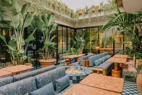 a restaurant with blue couches and tables and plants at Wilde Aparthotels Lisbon Liberdade in Lisbon