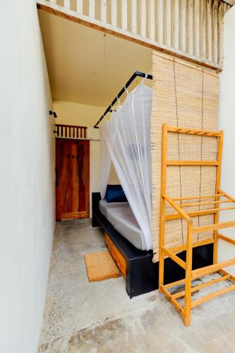 a bed in a room with a net at Malkoha Studios in Dickwella