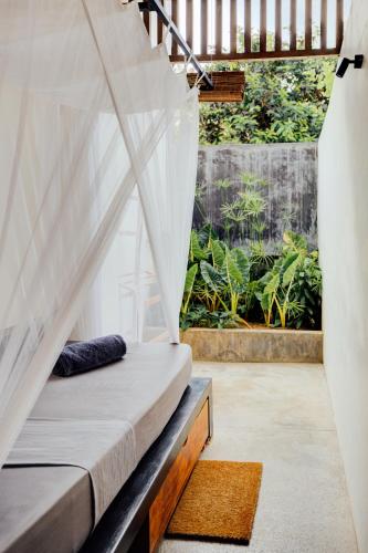 a bed in a room with a window at Malkoha Studios in Dickwella
