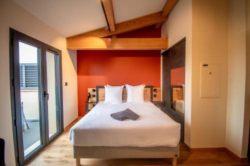 a bedroom with a large white bed with an orange wall at Lieu-dit Boulage in Marquefave