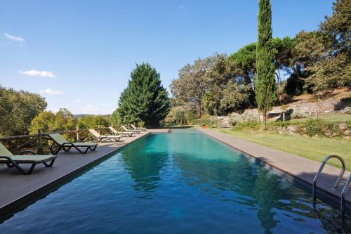 a swimming pool with chaise lounge chairs in a park at Casa de Andrães Loft Heras in Marco de Canaveses